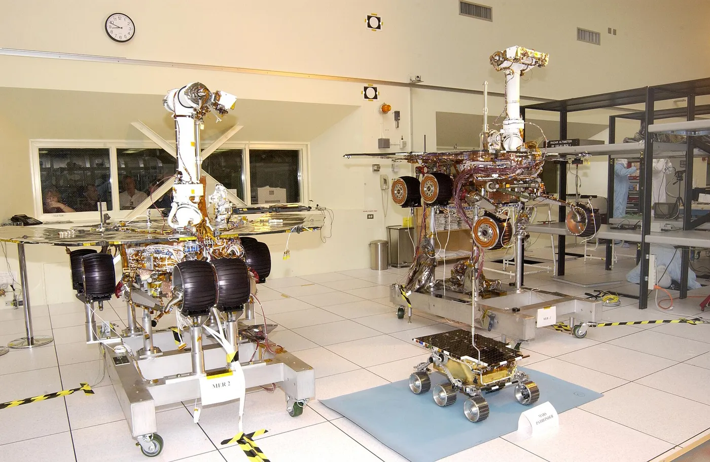 The twin rovers of the Mars Exploration Rover mission (Spirit left and Opportunity right) pose with their groundbreaking predecessor, the flight…