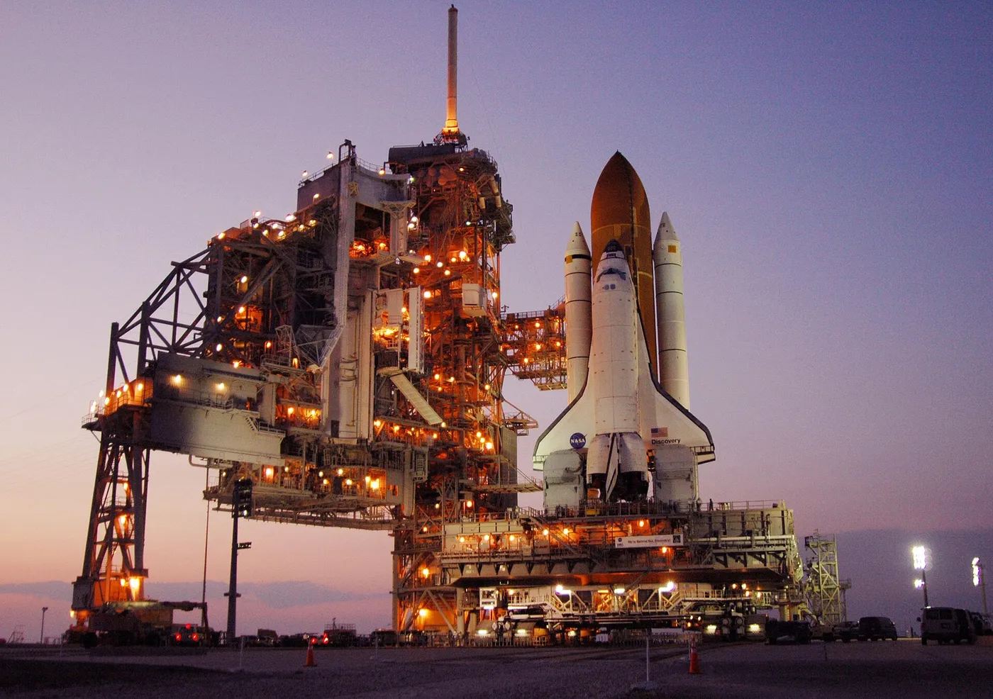 Amid the glow of lights from the fixed and rotating service structures, Space Shuttle Discovery rests on the hardstand of Launch Pad 39B at NASA's…