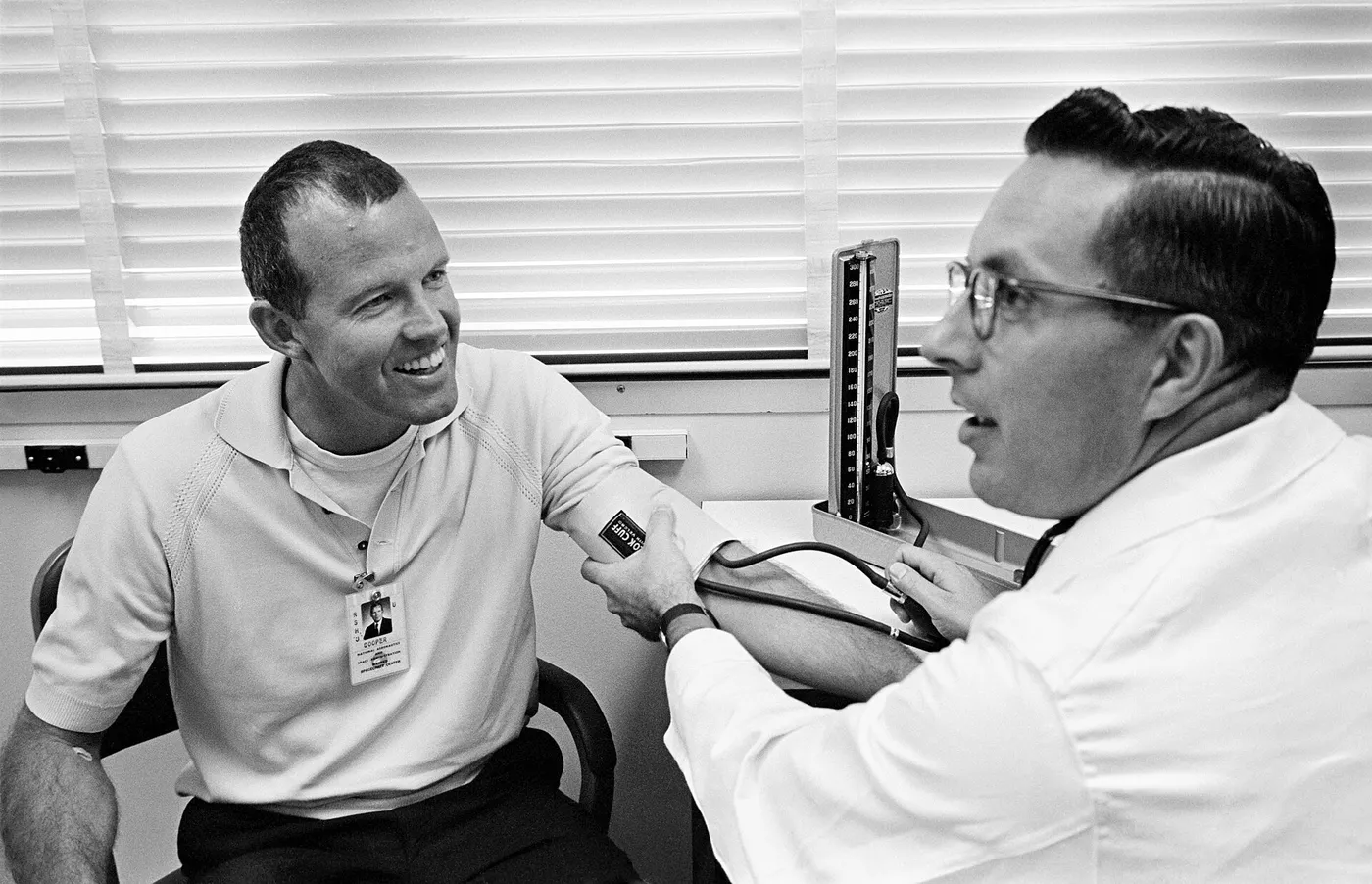 Astronaut L. Gordon Cooper Jr. has his blood pressure checked by Dr. Charles A. Berry