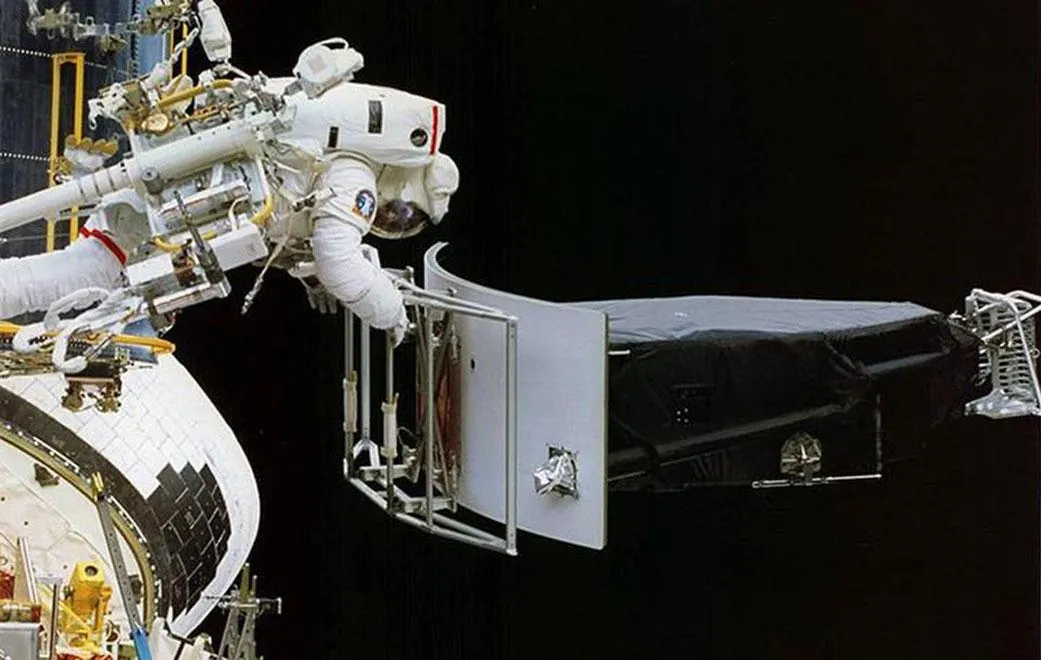 Astronaut Jeffrey Hoffman removes the Wide Field and Planetary Camera 1 (WFPC 1) during the first Hubble servicing mission (SM1), which took place in…