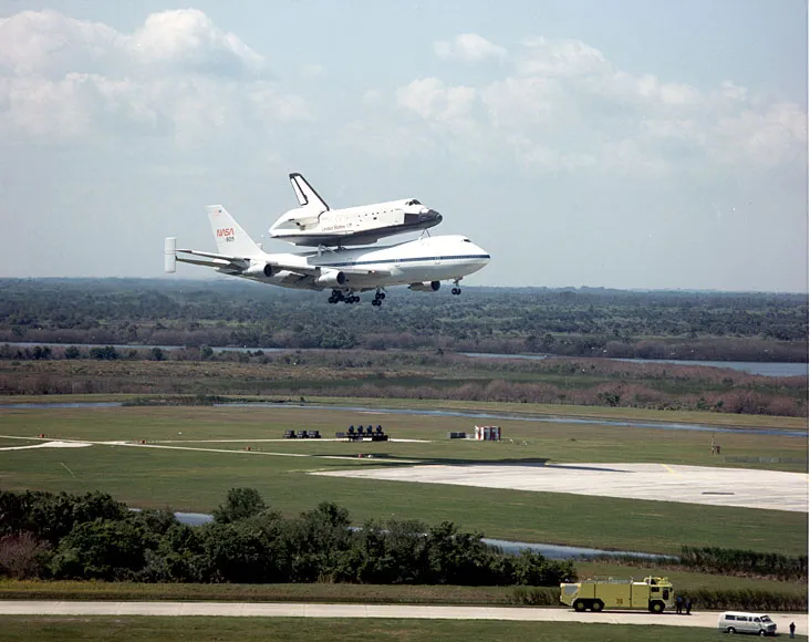 NASA space shuttle orbiter Challenger, riding on the 747/shuttle carrier aircraft, returns to Kennedy Space Center after landing at Edwards Air Force…