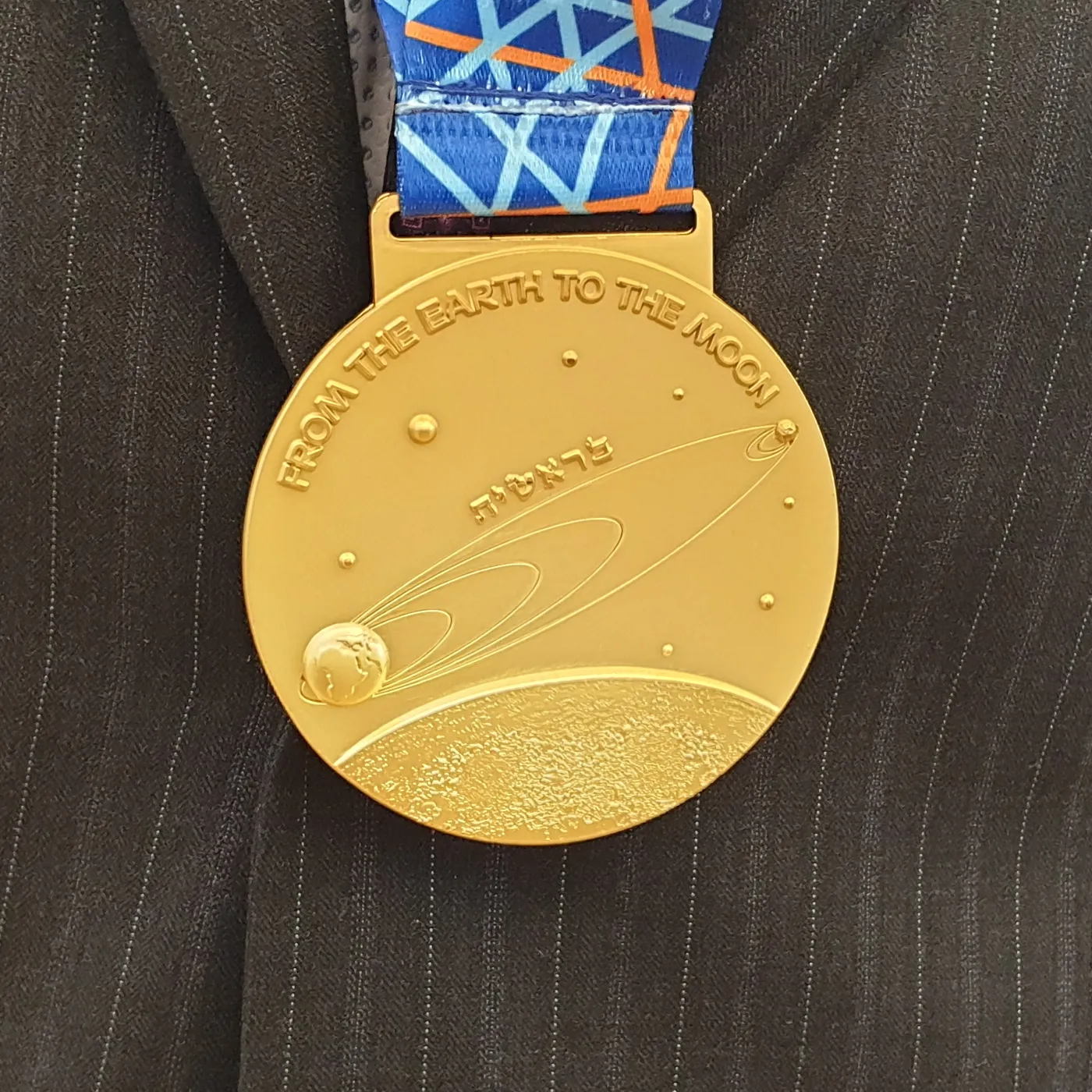Back side of a gold medal of the 2019 International Physics Olympiad in Tel Aviv, Israel. The medal depicts the trajectory of the Beresheet lunar…