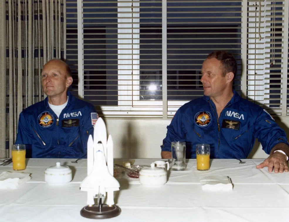 On launch day morning, STS-3 astronauts C. Gordon Fullerton, left, and Jack R. Lousma enjoy the traditional prelaunch breakfast in crew quarters at…