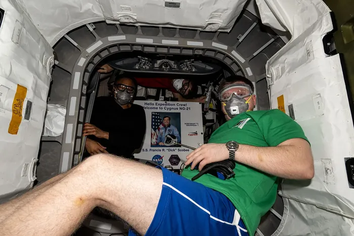 NASA astronauts enter the Cygnus space freighter