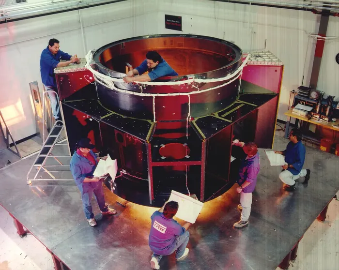 Technicians prepare main structural element (Bus) of CXO spacecraft for vibration testing at TRW (now NGST), Redondo Beach, CA.