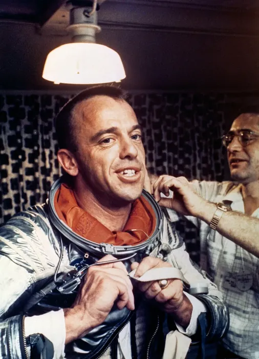 S88-31382 (5 May 1961) --- Astronaut Alan B. Shepard receives assistance in removing his spacesuit while on the U.S. Champlain after the recovery of…