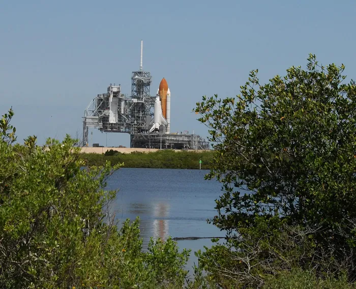 Reflected in the water of the Banana River at Kennedy Space Center, Fla., Space Shuttle Atlantis sits on Launch Pad 39A.