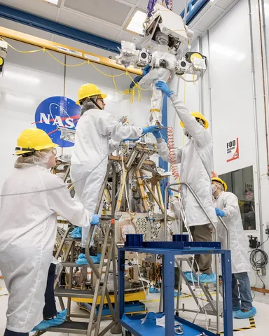 A team of engineers lifts the mast into place atop of NASA’s VIPER robotic Moon rover in a clean room at NASA’s Johnson Space Center in Houston.…