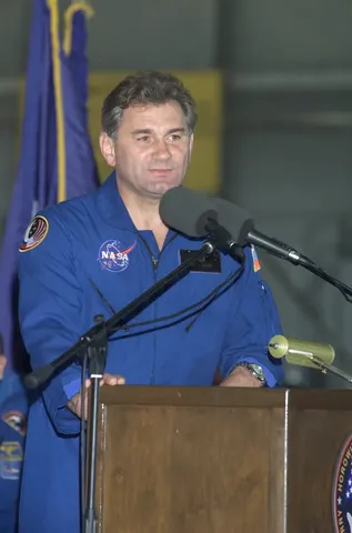Vasili V. Tsibliyev of Rosaviakosmos speaks from the podium in Hangar 990 at Ellington Field during the STS-105 and Expedition Two crew return…