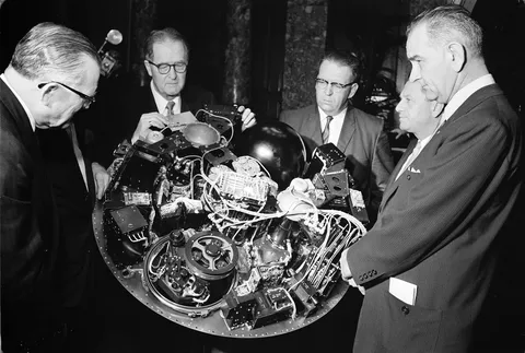 William G. Stroud of NASA (center-left), project manager of the TIROS I, displaying the satellite circuitry to Lyndon B. Johnson (right) and others