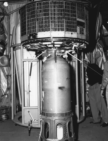 TIROS 2 satellite atop of launch vehicle, under hangar roof