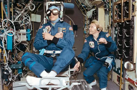 STS-58 Payload Commander Rhea Seddon spins the Spacelab Life Sciences rotating chair as Payload Specialist Martin Fettman serves as a test subject…