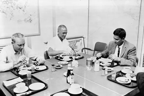 S62-00966 (20 Feb. 1962) --- Astronaut John H. Glenn Jr. (center) eats breakfast the morning of the launch of his Mercury-Atlas 6 (MA-6)spacecraft.…