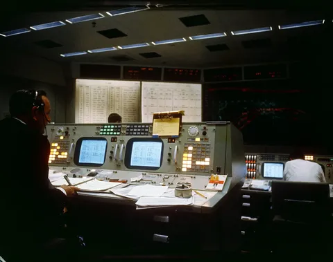 S65-60039 (7 Dec. 1965) --- Christopher C. Kraft Jr. (left), assistant director for Flight Operations, monitors his console in the Mission Control…