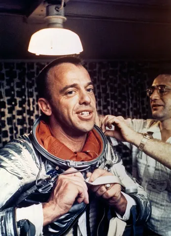 S88-31382 (5 May 1961) --- Astronaut Alan B. Shepard receives assistance in removing his spacesuit while on the U.S. Champlain after the recovery of…