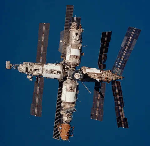 A cropped, colour corrected photo of Mir from STS-89, against the earths ocean.