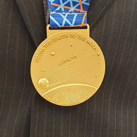 Back side of a gold medal of the 2019 International Physics Olympiad in Tel Aviv, Israel. The medal depicts the trajectory of the Beresheet lunar…