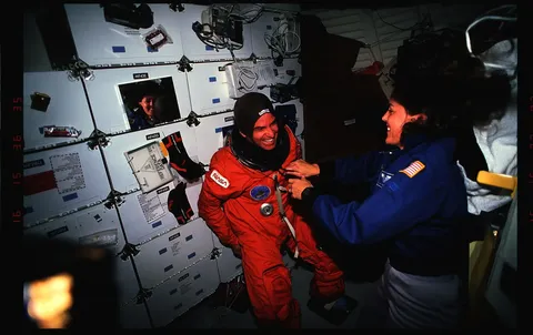 S49 48 010 Crewmembers in the mid deck donning liftoff landing suits prior to deorbit. DPLA 883a6555da53e0c86336425c9c31707d