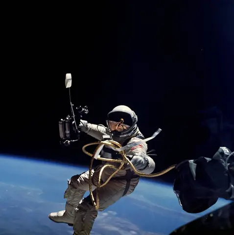Ed White manoeuvres on his tether with the hand-held oxygen gun during the first American spacewalk.